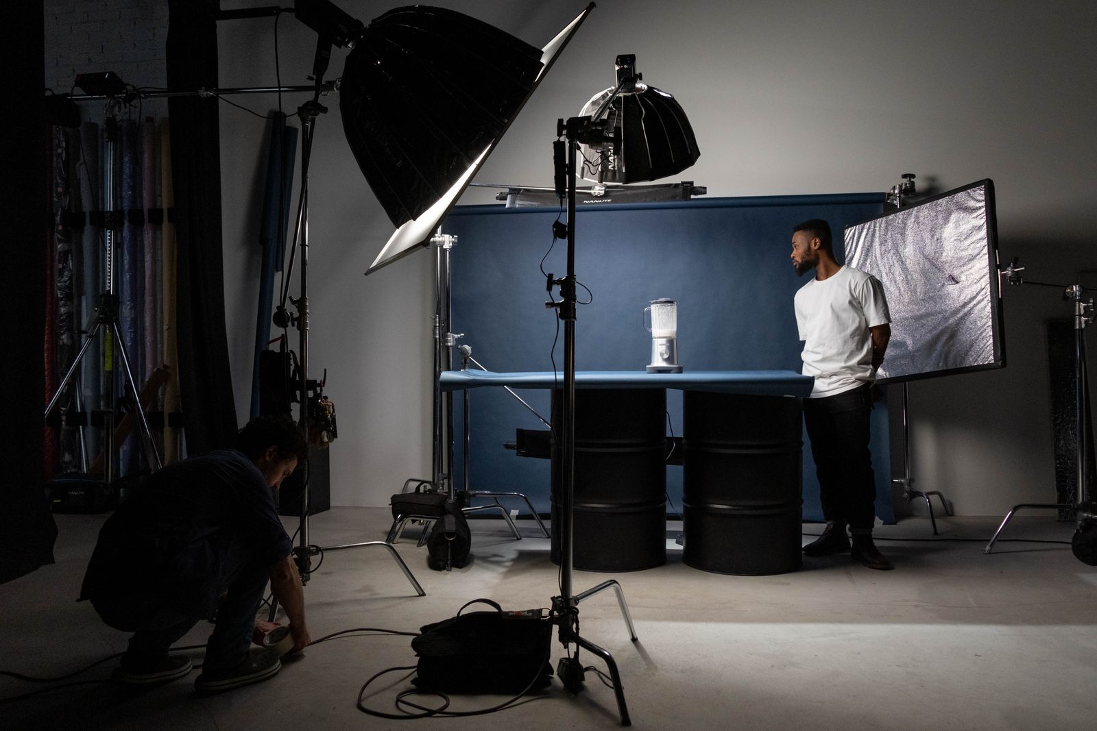 A creator filming under a softbox light stand, the kind of handheld setup where breathing and small hand movements quietly turn into visible shake on the final video.