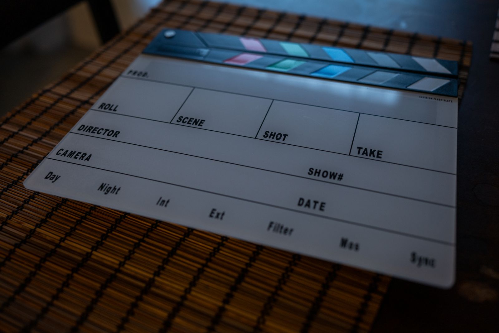 A clapperboard resting on an editing workspace beside a laptop, the moment a finished cut gets its final professional proof before it is released.