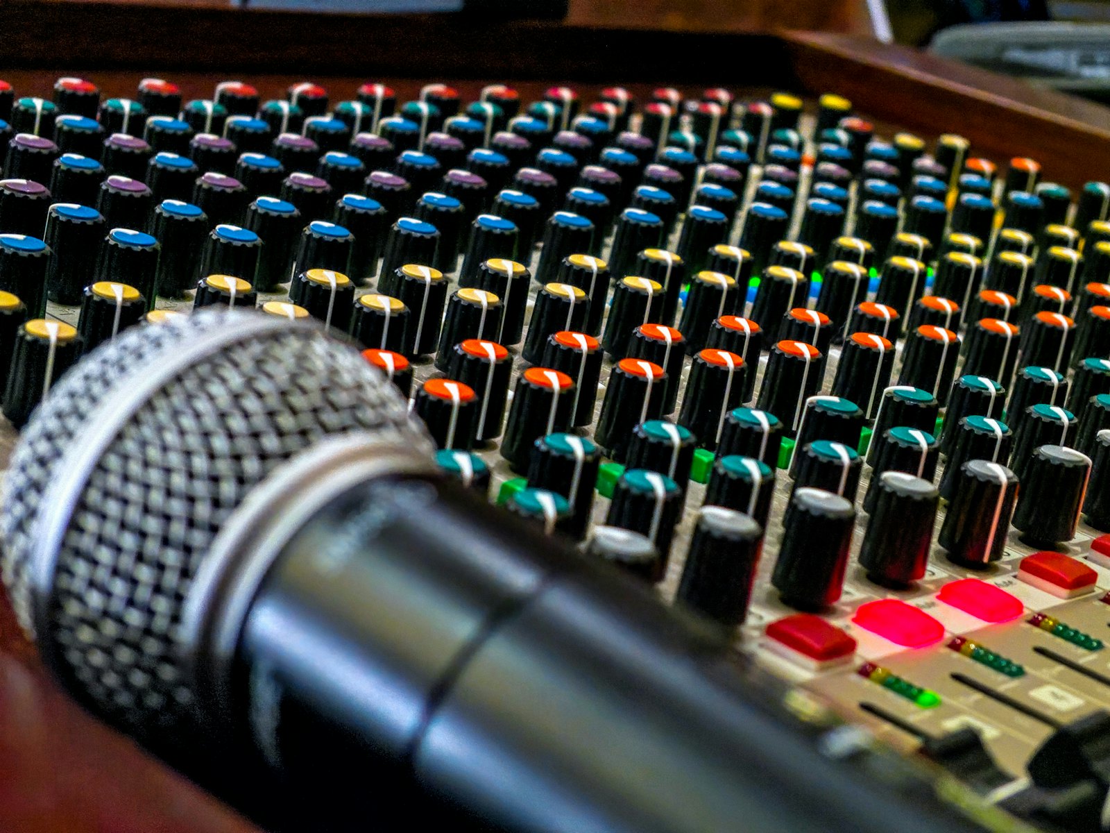 A microphone resting across a mixing board crowded with level knobs, a reminder that sound, not picture, is where most videos quietly lose their audience.