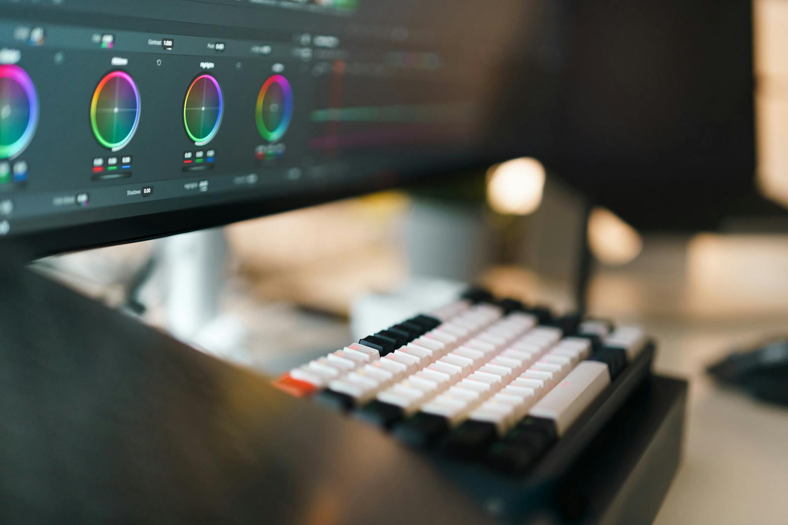 A colour-grading panel open on an editing monitor beside a mechanical keyboard, the desk where a video gets its final quality check before it is published.