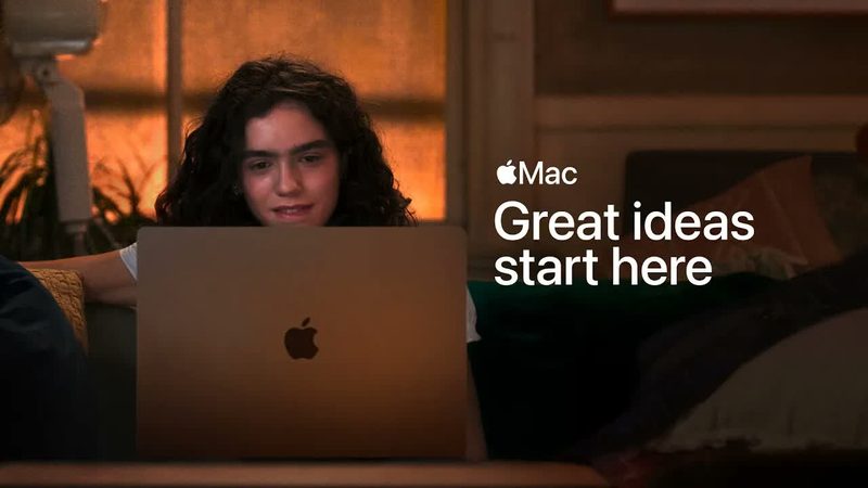 Cinematic warm-lit frame of a student working on a MacBook at night, captioned Great ideas start here